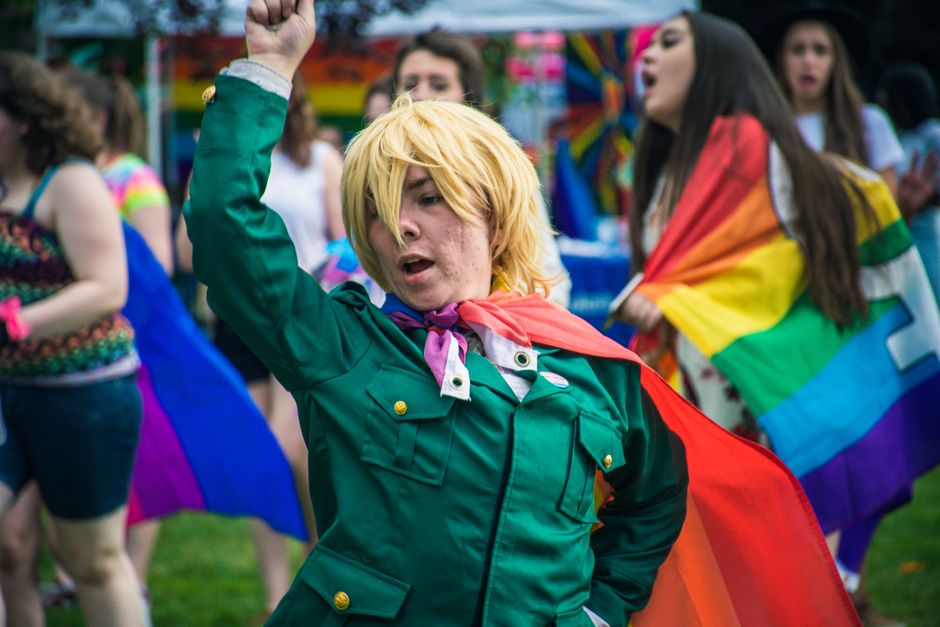 A lively group of cosplayers posing outdoors, showcasing colorful costumes in a cheerful setting.